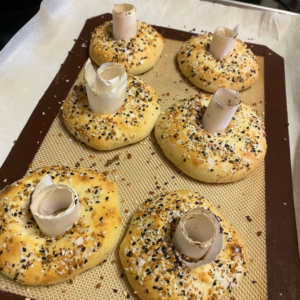bagels on silicone baking mat with tubes holding holes open