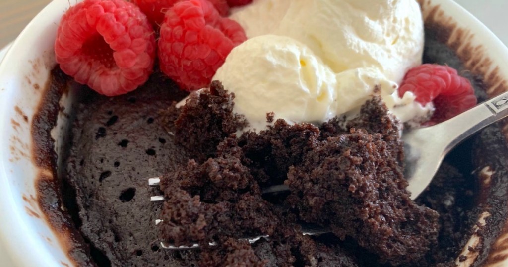 a fork in keto chocolate mug cake with fresh berries