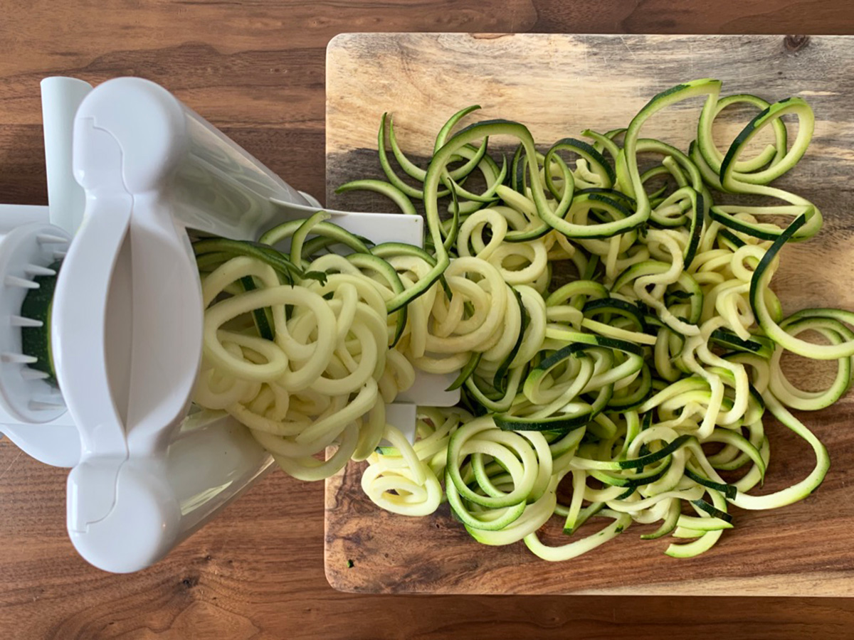 zucchini being spiralized into noodles