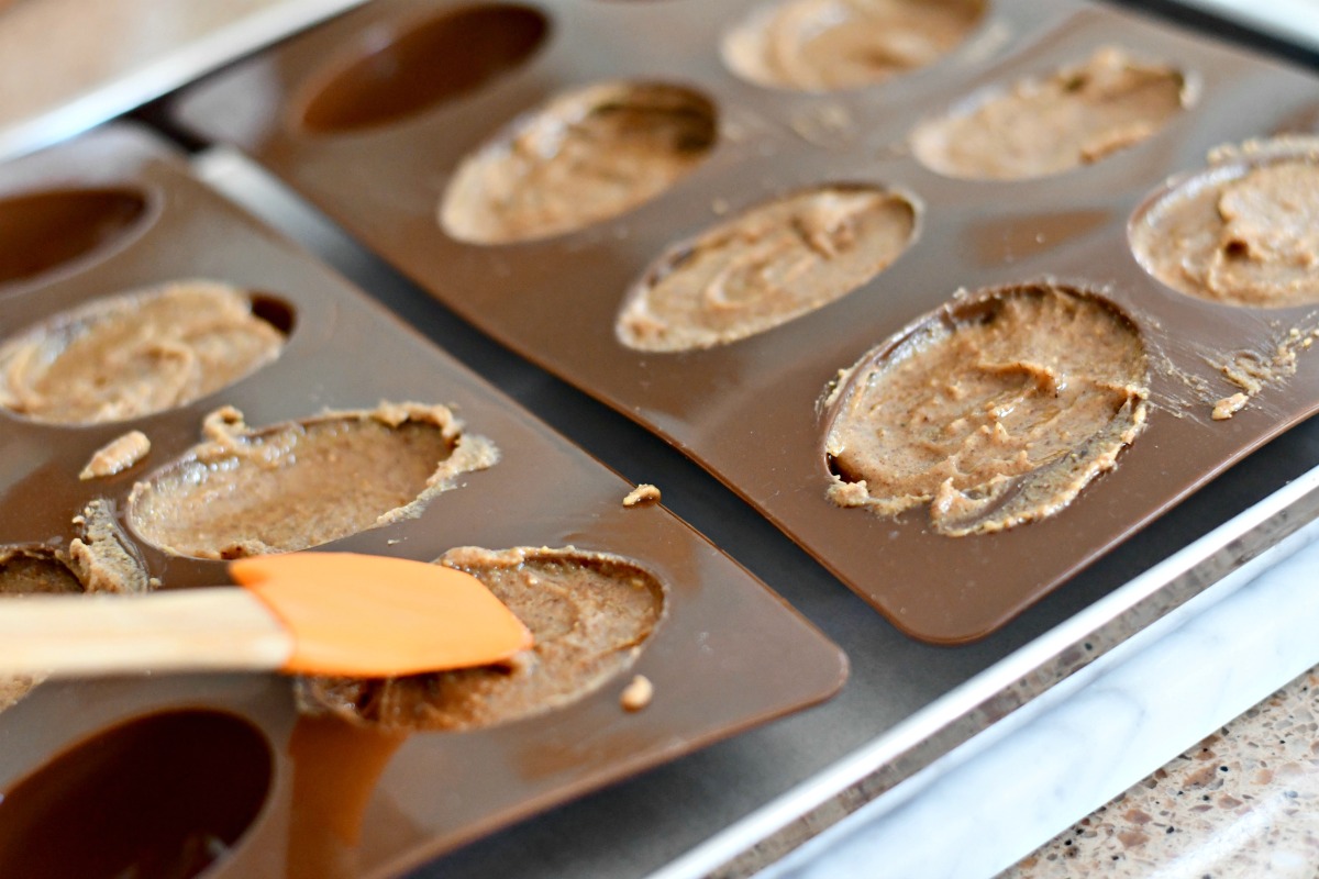 spreading almond butter filling in egg molds for candy 