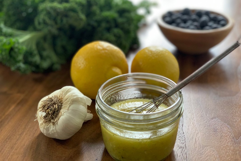 a small mason jar with dressing for kale salad