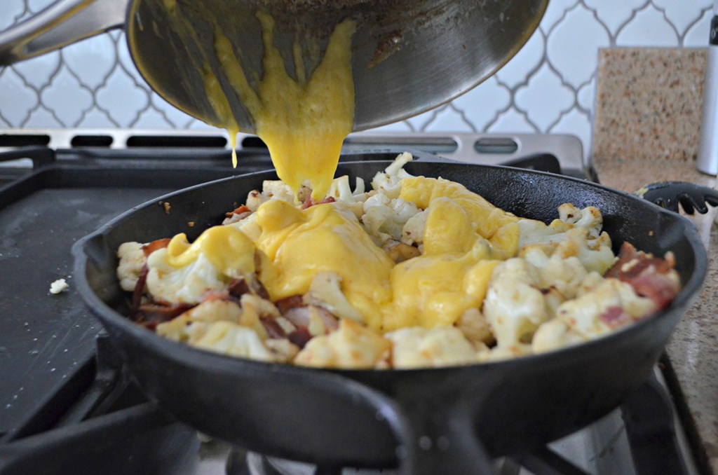 pouring melted cheese onto cauliflower