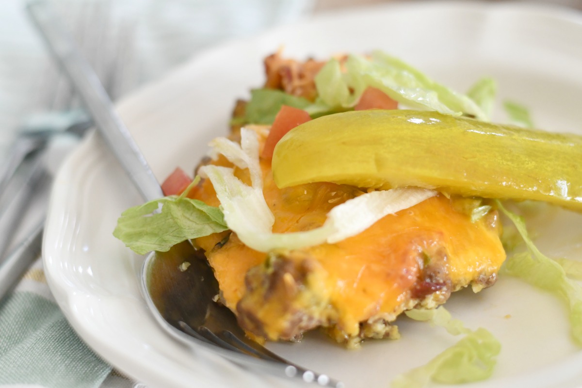 piece of keto cheeseburger casserole served with pickle and lettuce