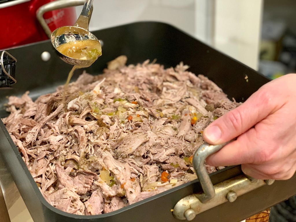 pouring sauce over pork roast 