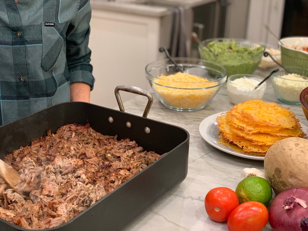 shredded pork in pan with toppings (shredded cheese, sour cream, vegetables and more)