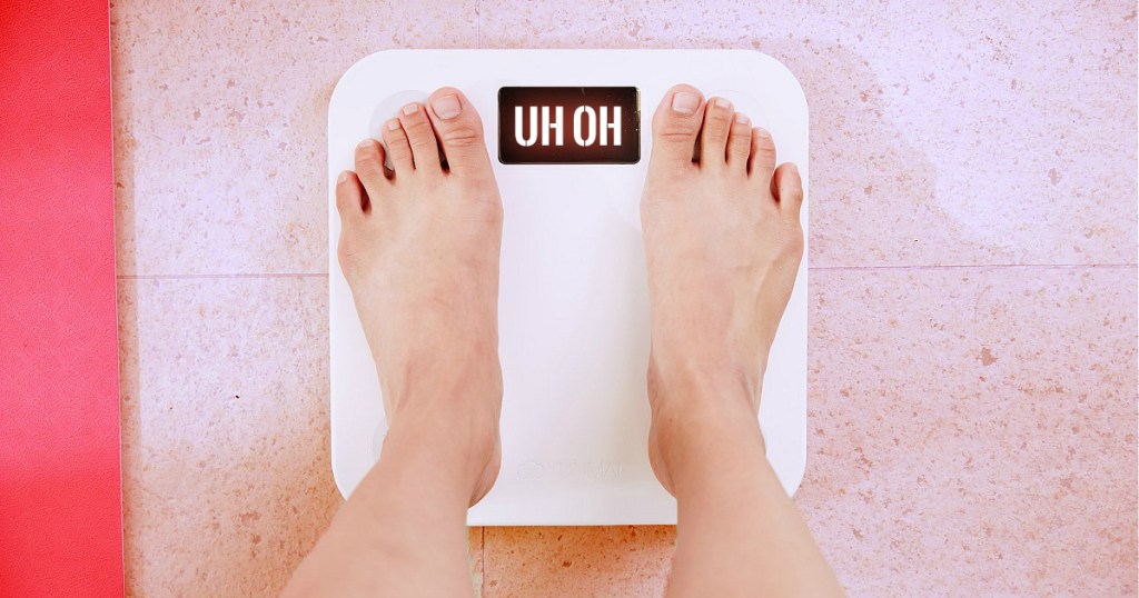 Top view of feet on weighing scale. Women weigh on a weight