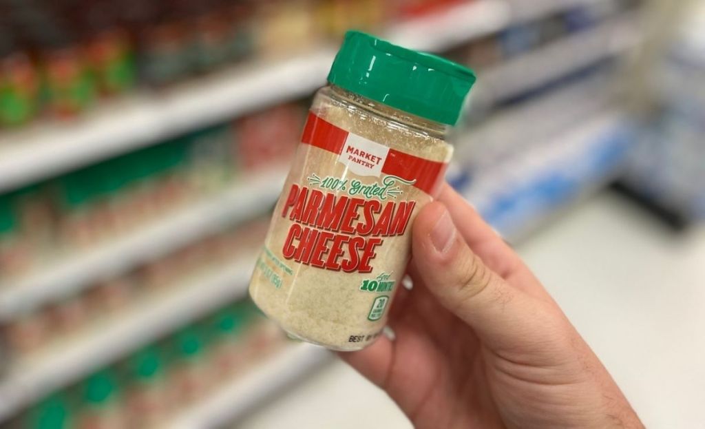 A hand holding some parmesan cheese at a store