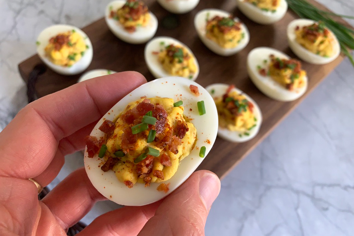 holding up bacon deviled egg