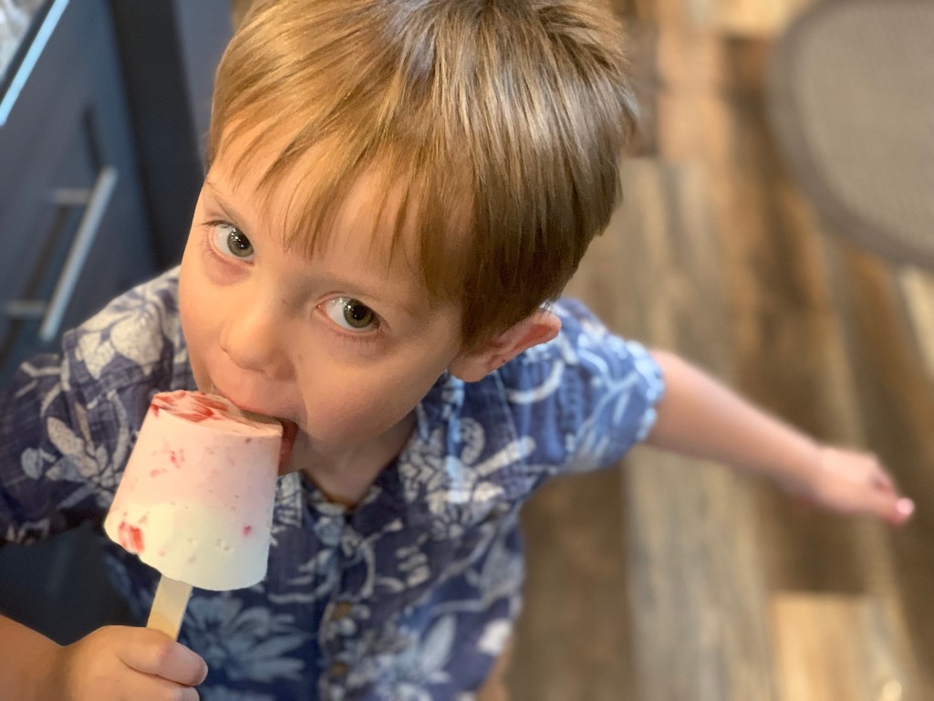 little boy eating keto cheesecake popsicle 