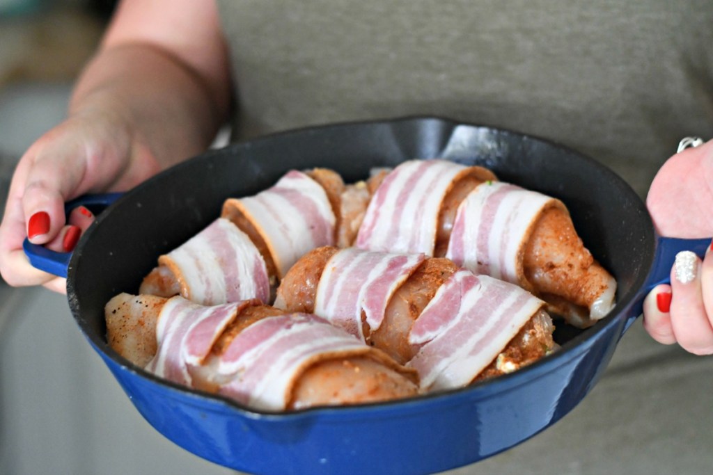 holding a pan with cheesy broccoli keto stuffed chicken