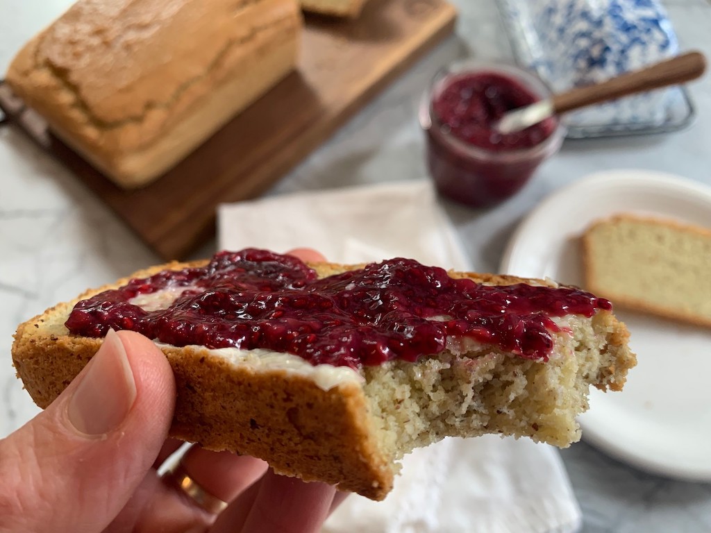 holding keto bread with sugar free jam 