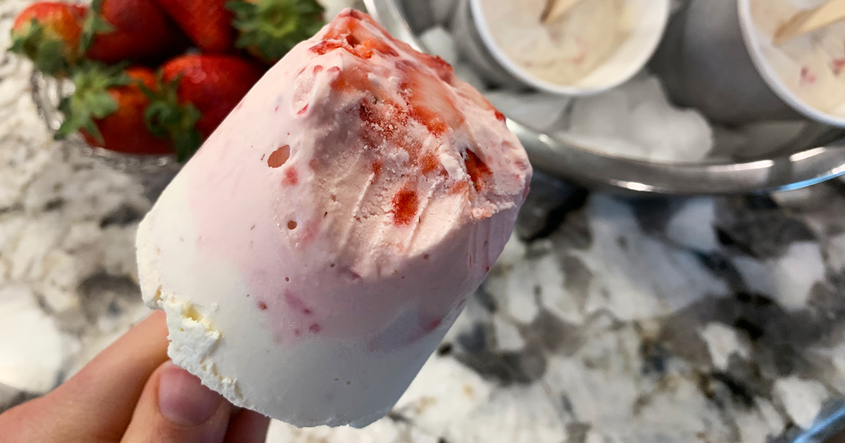 a strawberry cheesecake popsicle with a bite taken out