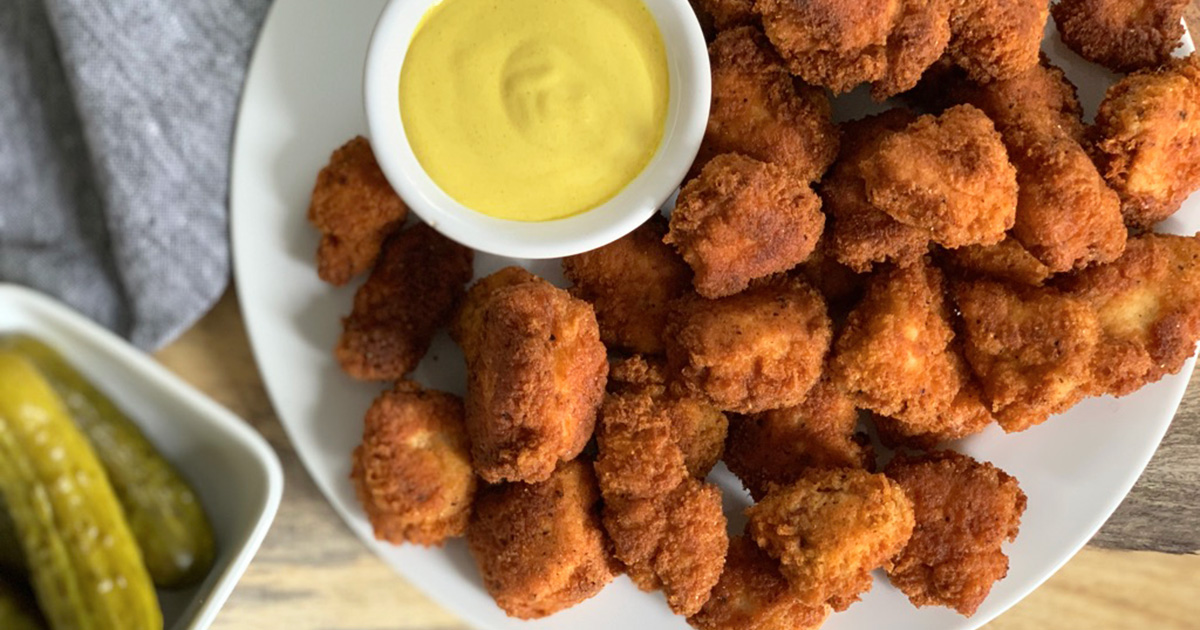 a dish full of southern fried pickle brined chicken bites with mustard dipping sauce