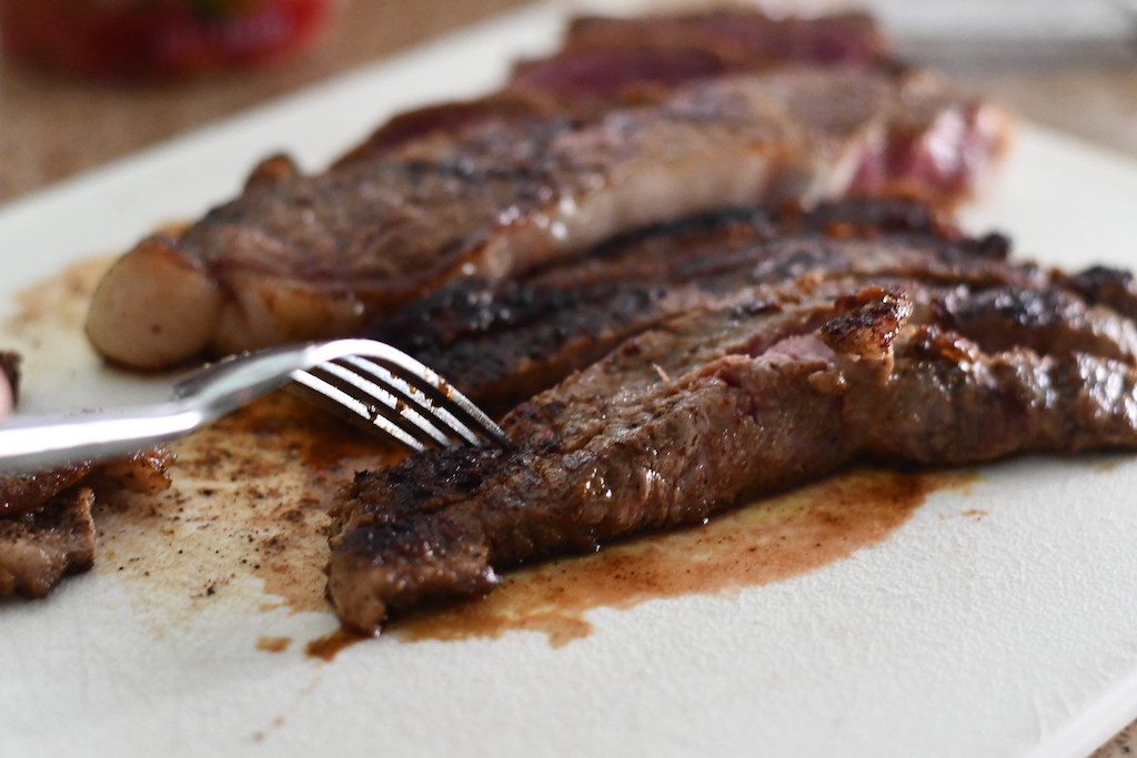 cutting into ribeye steak