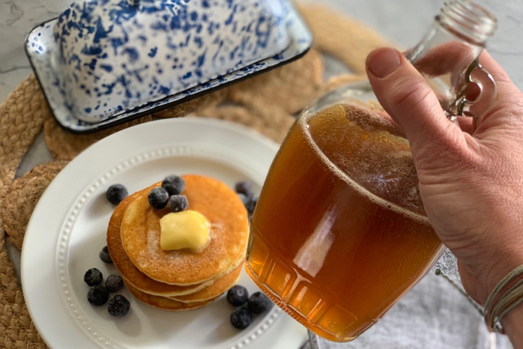 a hand holding a bottle of keto pancake syrup