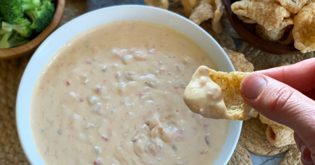 a pork rind dipped in Mexican queso dip