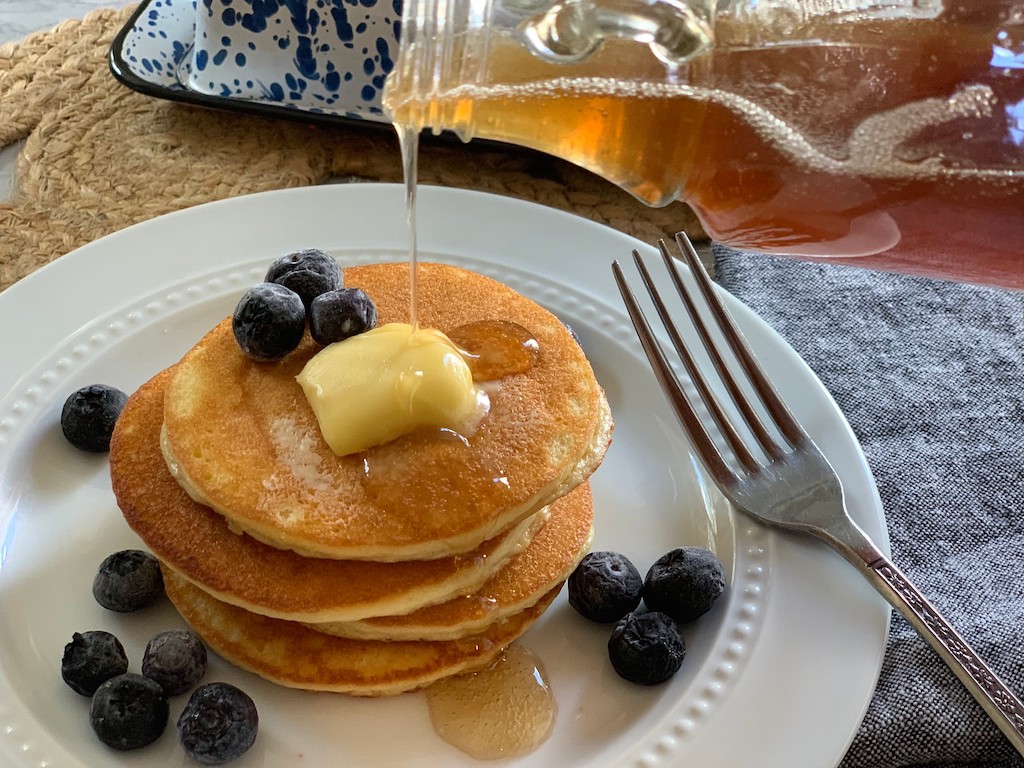 Keto pancakes with sugar free syrup being poured on them