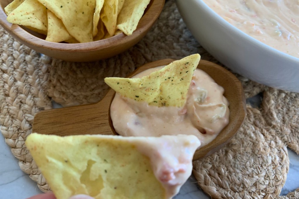 a Quest chip being eaten with cheesy queso dip