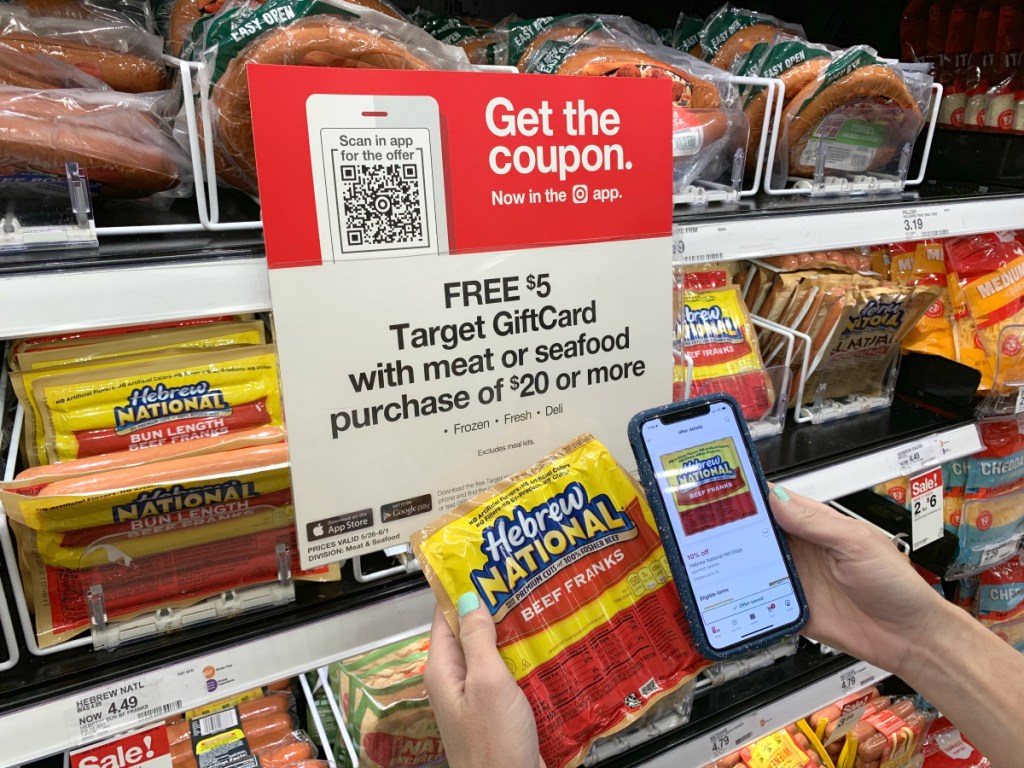 person holding package of Hebrew National hot dogs and phone at Target