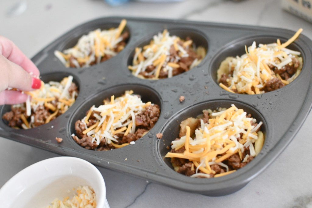 adding cheese to cheeseburger muffins