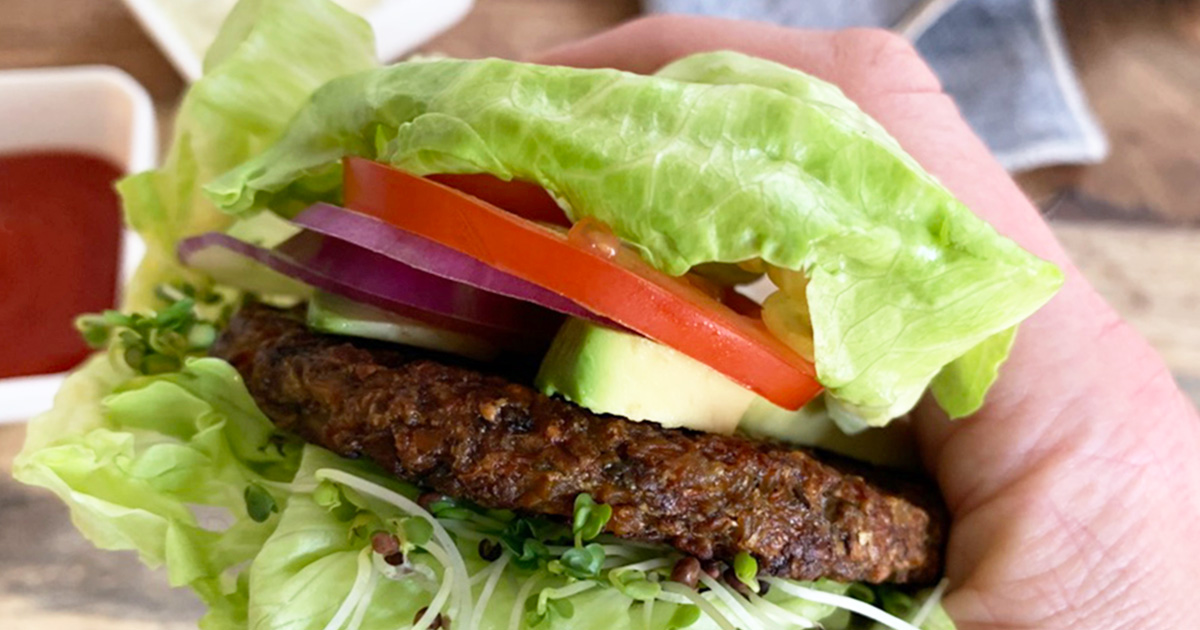 a lettuce wrapped veggie burger ready to bite into