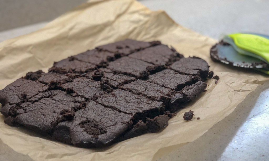 fudgy keto brownies — keto brownies on parchment paper cooling out of the oven