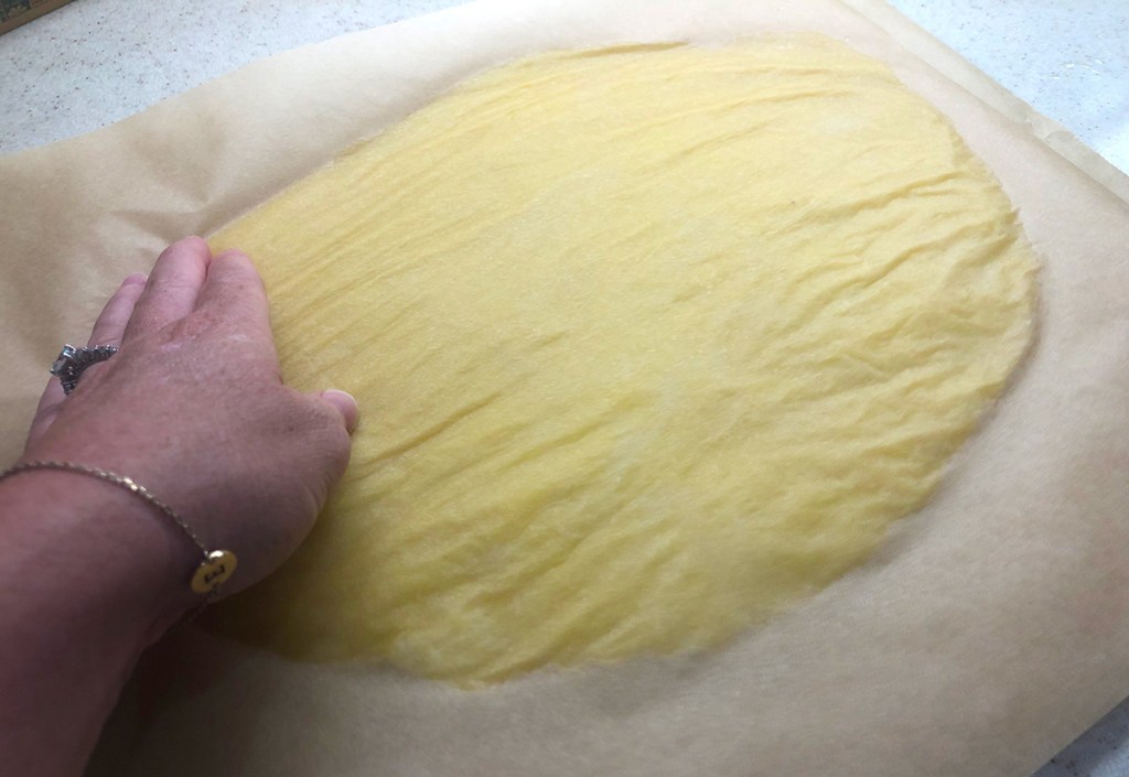 flattening out 2 ingredient dough between parchment paper