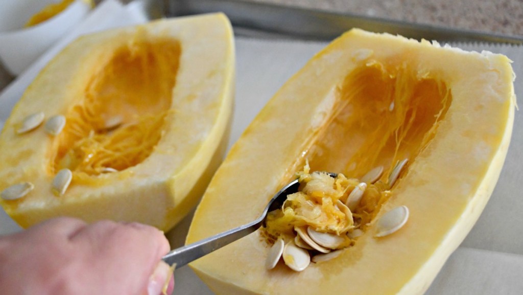 scraping pulp from spaghetti squash to prep for baking