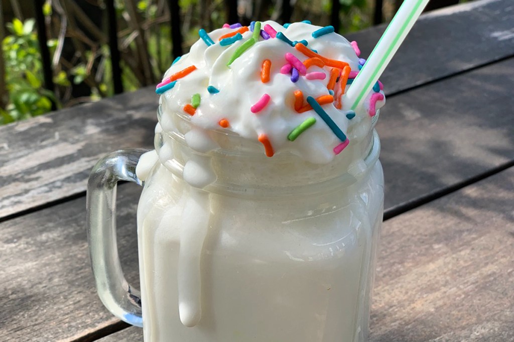 a dripping mason jar full of birthday cake protein shake