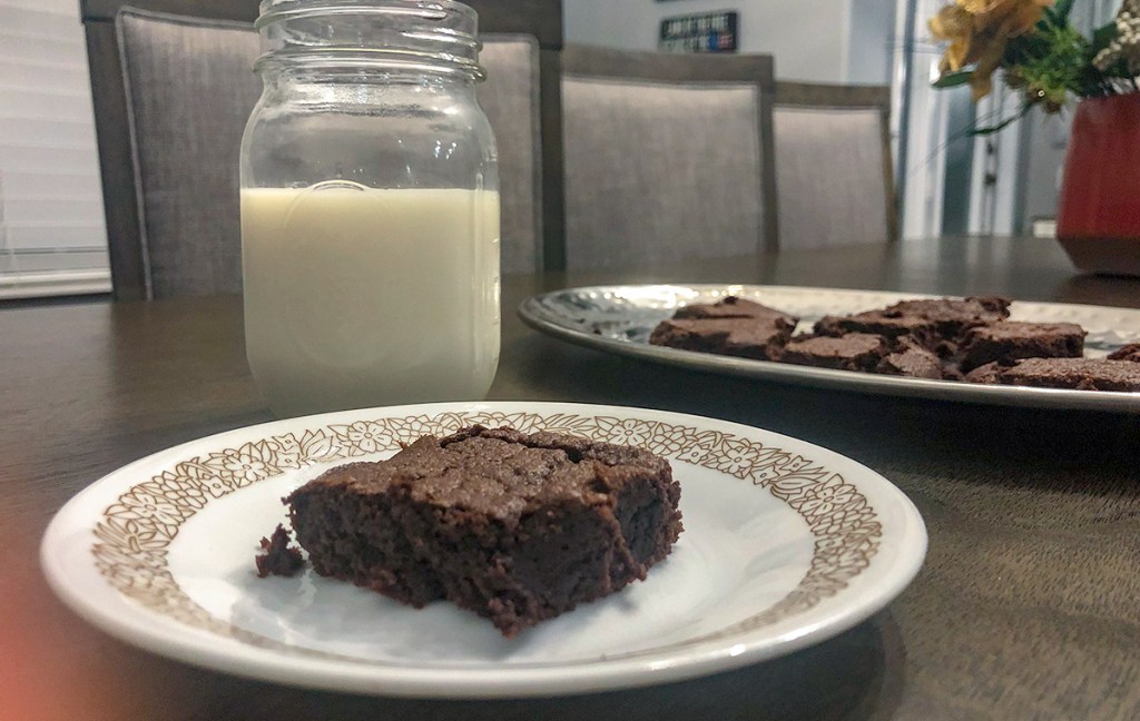 fudgy keto brownies — keto brownie on plate with glass of almond milk