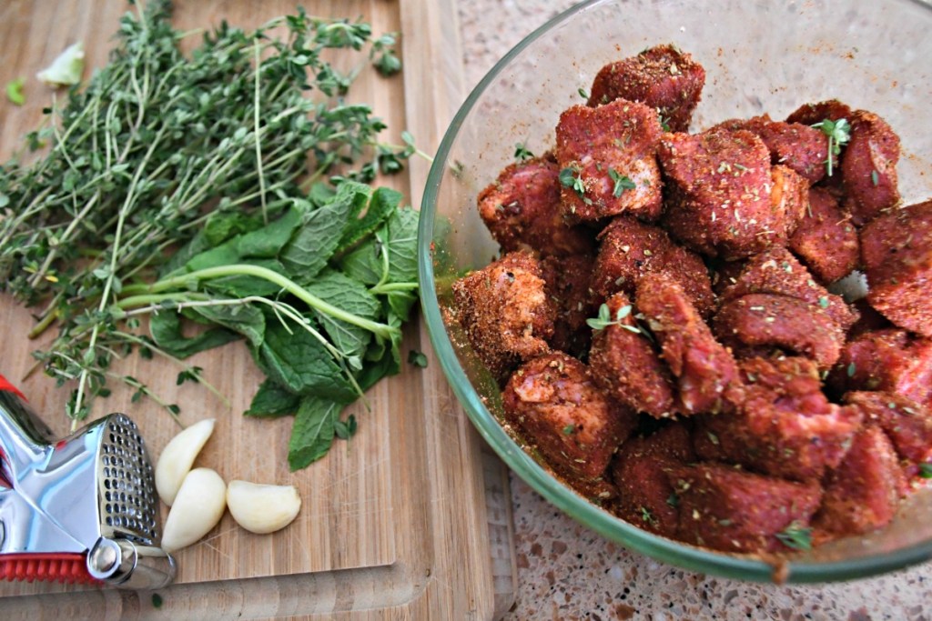 cajun seasoned steak cubes in a bowl with fresh herbs 