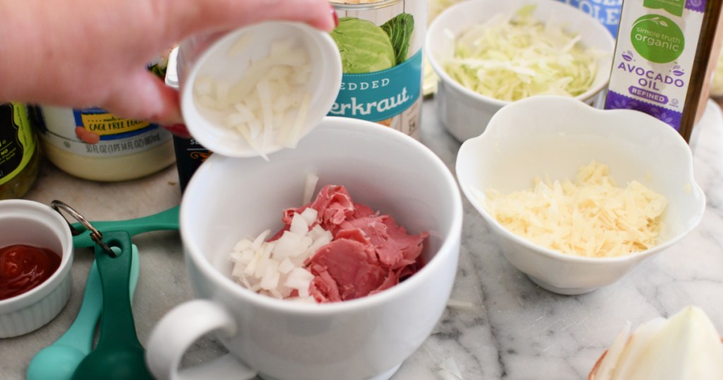 adding onion and corned beef to a mug