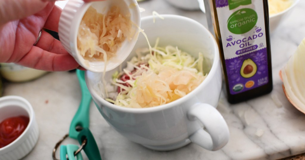 adding sauerkraut to a mug