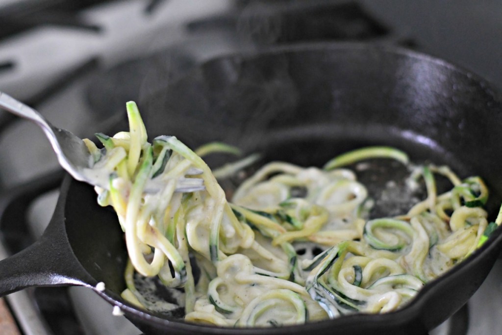 keto alfredo zoodles twisted in a fork 