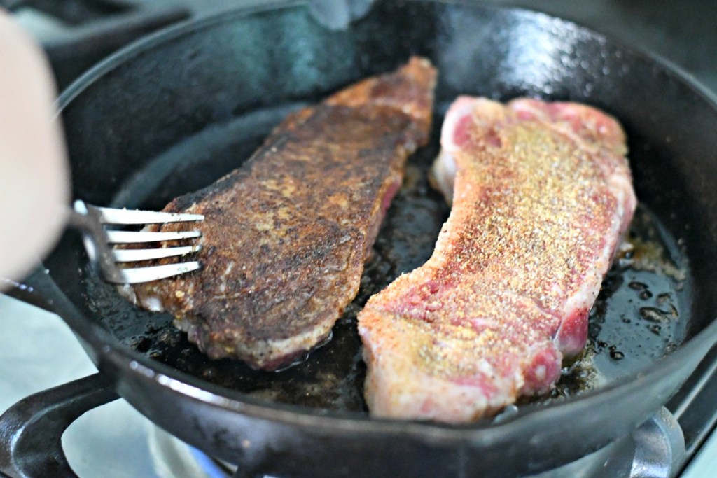 cooking steak on a cast iron pan