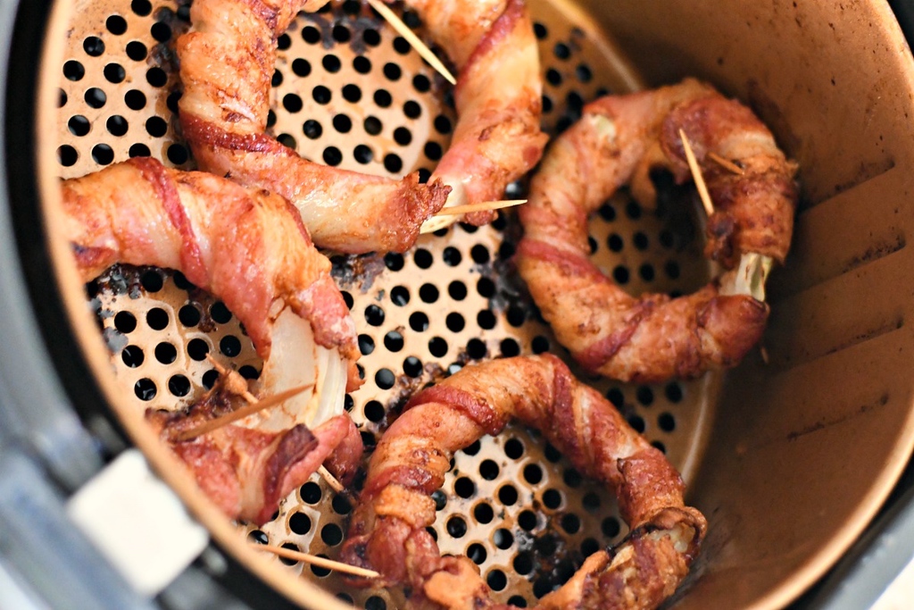 bacon wrapped onion rings cooking in air fryer 