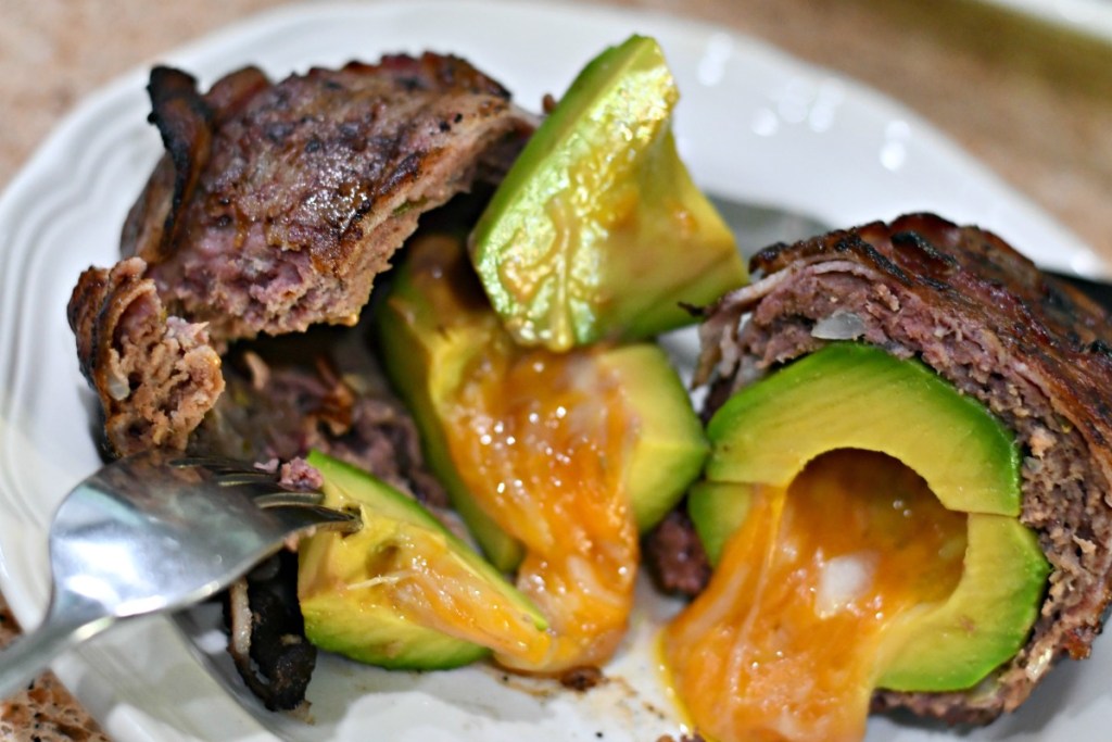 cutting into a burger avocado bomb