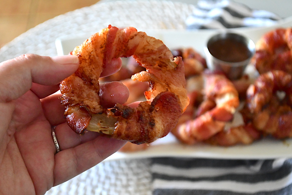 holding bacon-wrapped onion ring