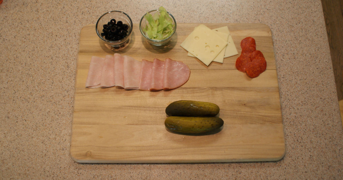 ingredients for a pickle sandwich on a cutting board