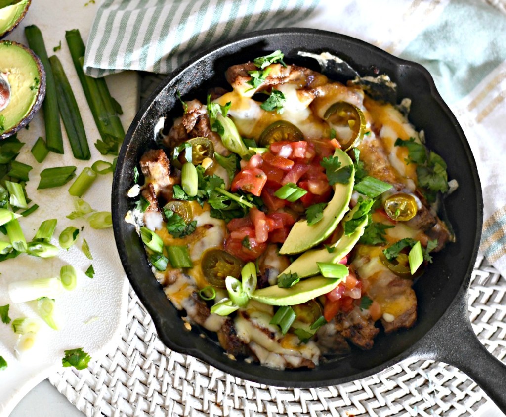 placing toppings on skillet nachos on the table