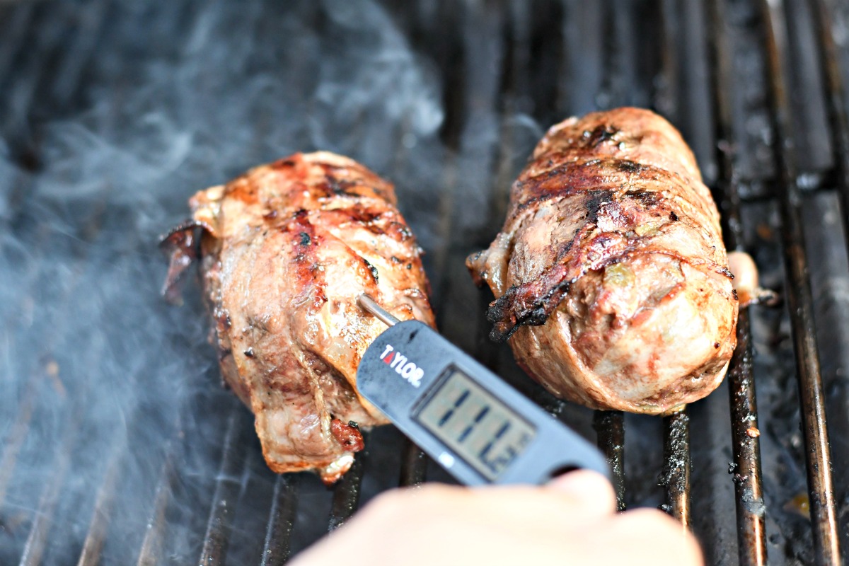 sticking a meat thermometer in the hamburger to check temperature