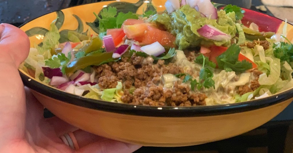 holding bowl of keto nachos 