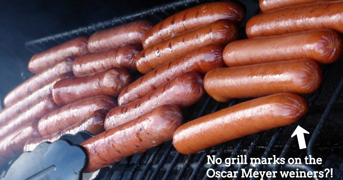 Perritos calientes en la parrilla uno al lado del otro