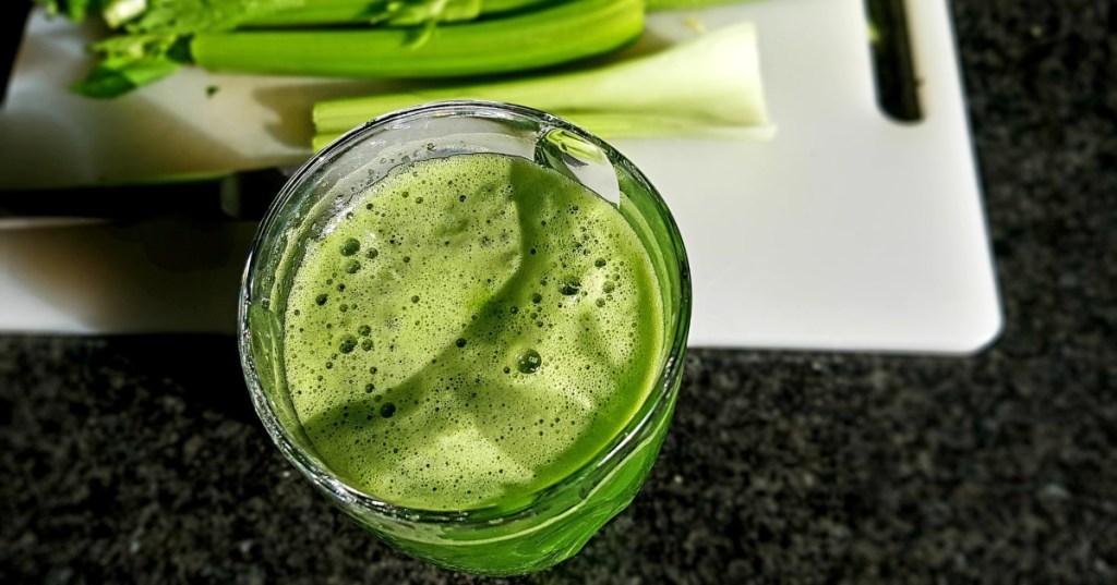 celery juice with celery on cutting board