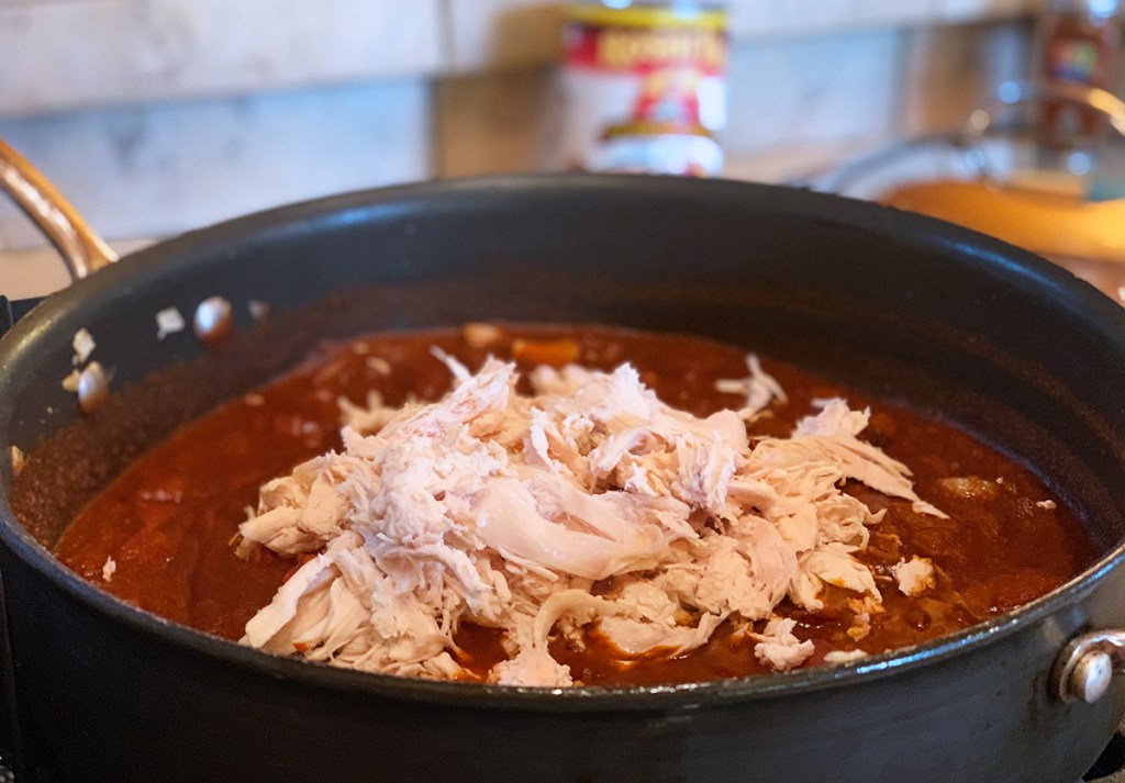 simmering chicken and enchilada sauce
