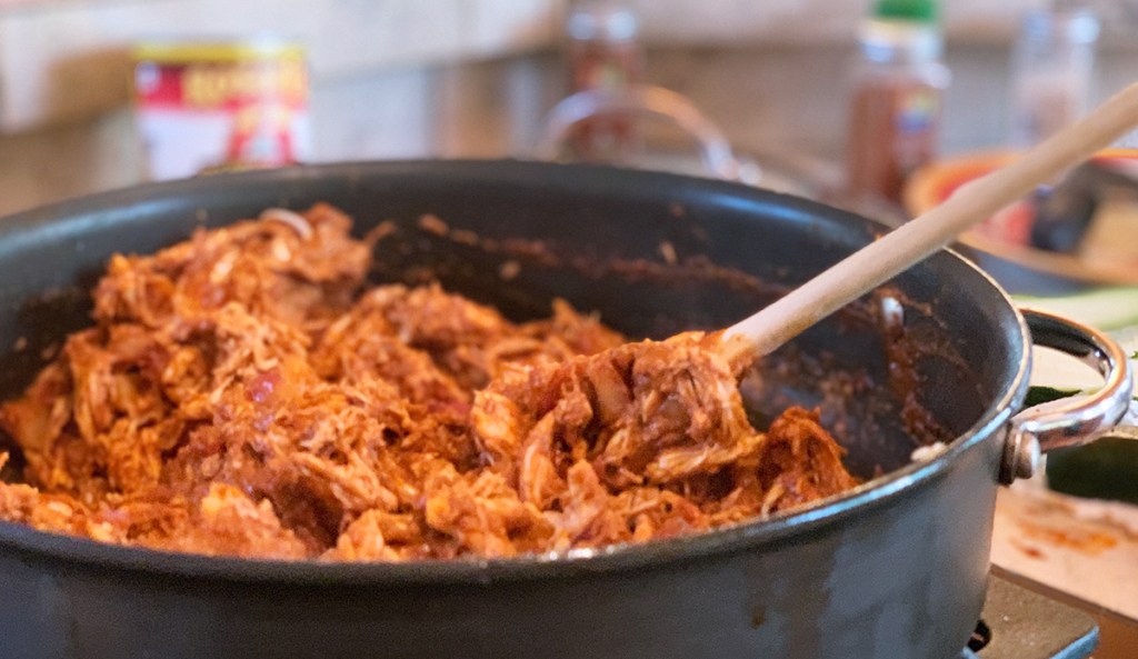 simmering chicken and enchilada sauce on the stove