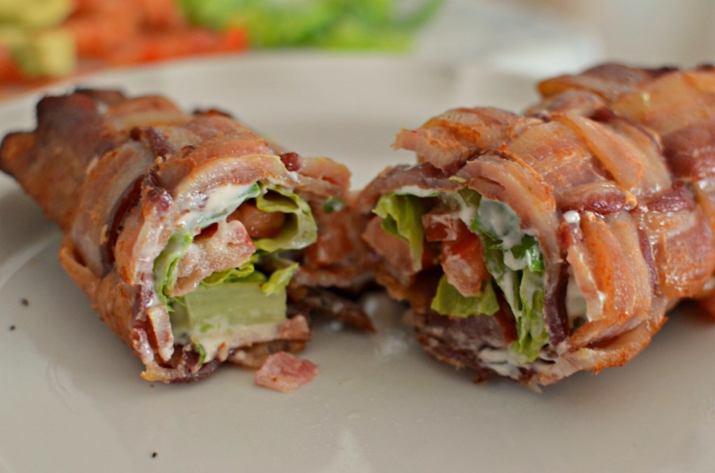 cutting up keto bacon sushi on a plate