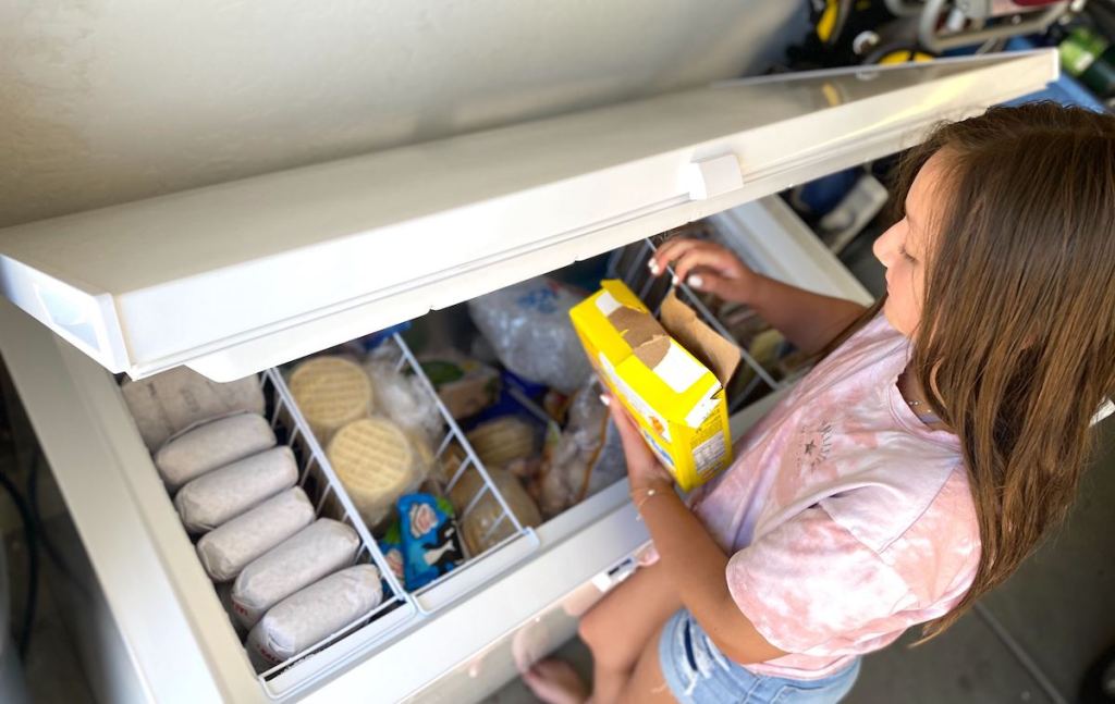 girl pulling food from deep freezer