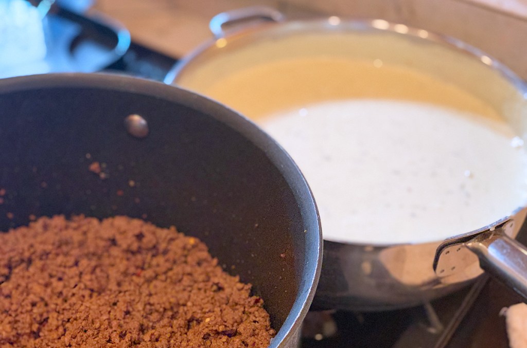 pan of cooked ground beef and queso on stove