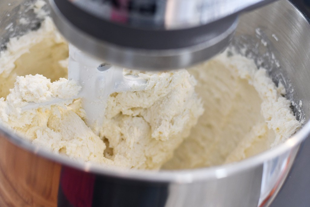 mixing cream cheese and sugar free keto sweetener in mixer for keto cheesecake